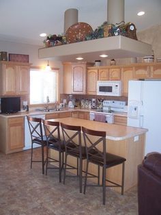 a kitchen with wooden cabinets and white refrigerator freezer next to a stove top oven