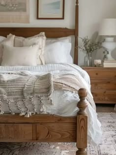 a bed with white linens and pillows in a bedroom