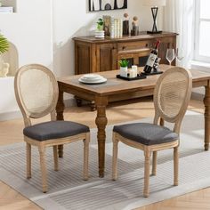 a dining room table with two chairs and a place mat on the floor in front of it