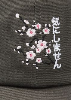 a baseball cap with flowers embroidered on the front and back side, in japanese script