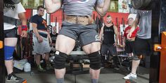 a man with knee pads on lifting a barbell