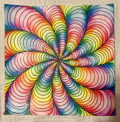 a colorful art piece on a white quilt with an image of a spiral design in the center