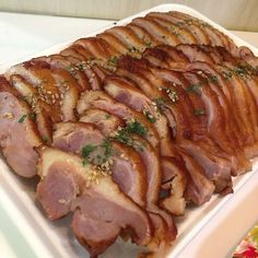 sliced ham on a white platter with parsley