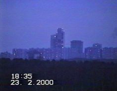 a city skyline is seen in the distance with buildings lit up at night behind it