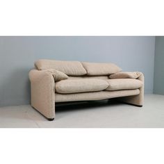 a beige couch sitting on top of a white floor