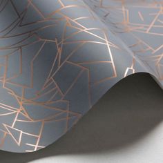 a close up view of a metallic wallpaper with gold lines and shapes on it