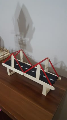 a wooden table topped with a toy car and ramp