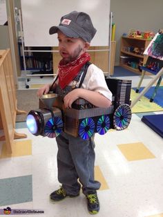 a young boy wearing a hat and holding a small toy car with lights on it