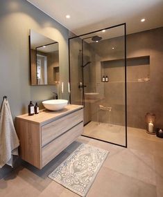 a bathroom with a sink, mirror and shower stall in it's own area