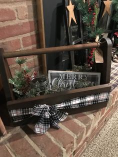 a wooden crate filled with christmas decorations on top of a brick fireplace