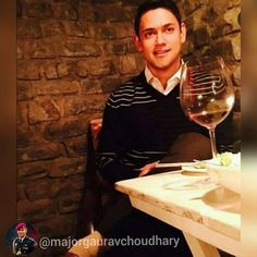 a man sitting at a table with a glass of wine