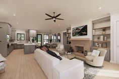 a person laying on a couch in a living room next to a kitchen and dining area