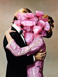 a man and woman hugging each other with pink sugar cubes on their shoulders