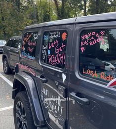 a jeep parked in a parking lot with lots of writing on the windows