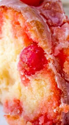 a close up view of a piece of cake with strawberries on it and icing