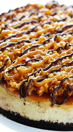 a cheesecake covered in caramel and chocolate drizzle