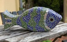 a mosaic fish sitting on top of a wooden table