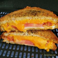 two grilled cheese sandwiches with ham and cheese on them are sitting on a grill