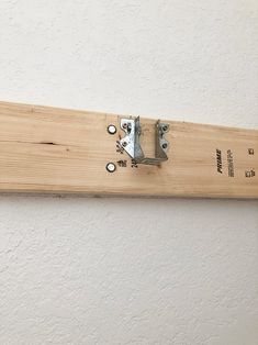 a piece of wood that has some metal latches on it and is attached to the wall