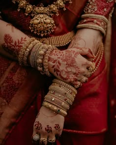 a close up of a woman's hands with hennap and bracelets