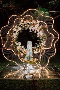 a large metal object with flowers on it in the middle of a field at night