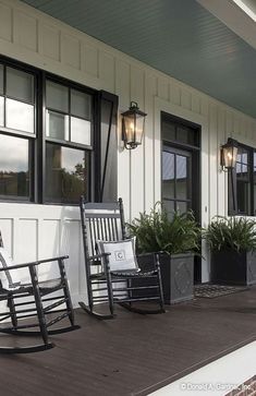 two rocking chairs on the front porch of a house