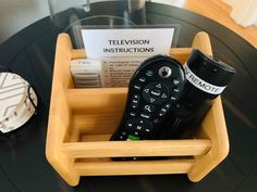 a remote control in a wooden holder on a table