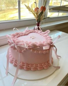 a pink cake sitting on top of a white counter