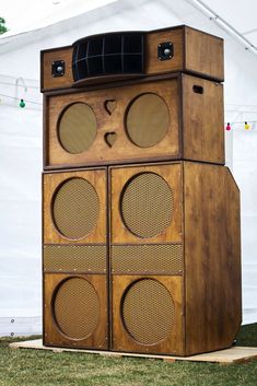 an old fashioned wooden radio tower with speakers on it's sides in front of a tent