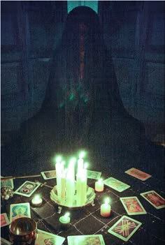 a person sitting at a table with candles in front of them and pictures on the table