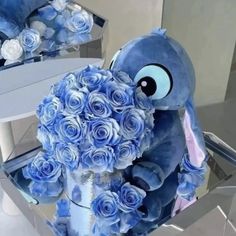 a blue stuffed animal holding a bouquet of roses