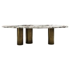 an oval marble dining table with three brass pedestals on each end and a white marble top