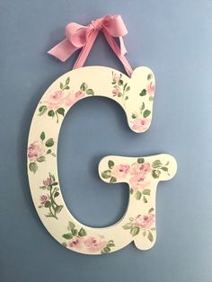 the letter g is decorated with pink flowers