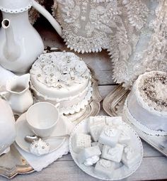 a table topped with white dishes covered in frosting