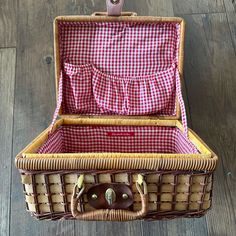 an open wicker suitcase sitting on top of a wooden floor