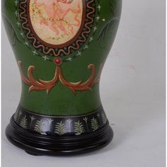 a green vase with an angel painted on it