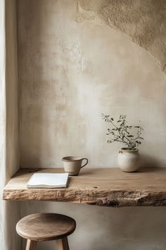 a wooden table topped with a potted plant next to a stool