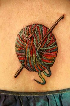 a woman's back shoulder with a colorful ball of yarn and knitting needles on it