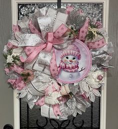 a pink and white wreath with a snowman on it