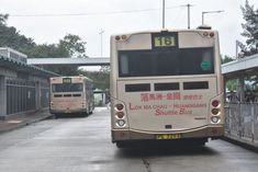 two buses are parked in front of a bus stop