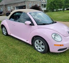 a pink car is parked in the grass