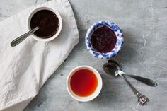 two cups of tea and spoons on top of a table with white paper towels