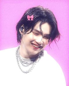 a man with black hair and a pink bow in his hair