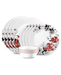 a set of white plates with red and black flowers