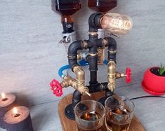 two glasses are sitting on top of a wooden stand with pipes and bottles in it