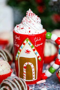 a red cup filled with white frosting and topped with a gingerbread house