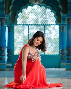 a woman in a red dress sitting on the floor