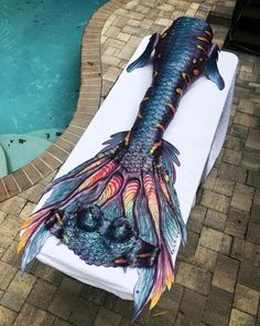 a large fish that is laying on top of a towel next to a swimming pool