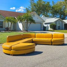 a yellow couch sitting in the middle of a driveway