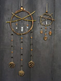 an assortment of pinecones hanging on a wooden wall with beads and chains attached to it